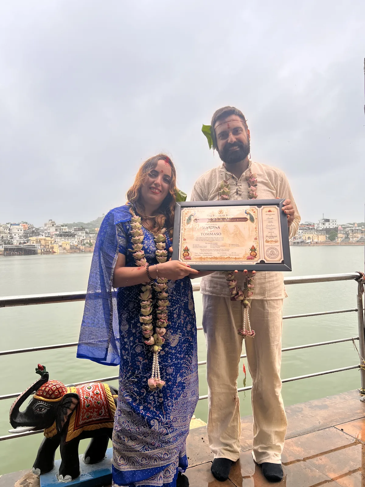 A couple hold a commemorative certificate after their ceremony