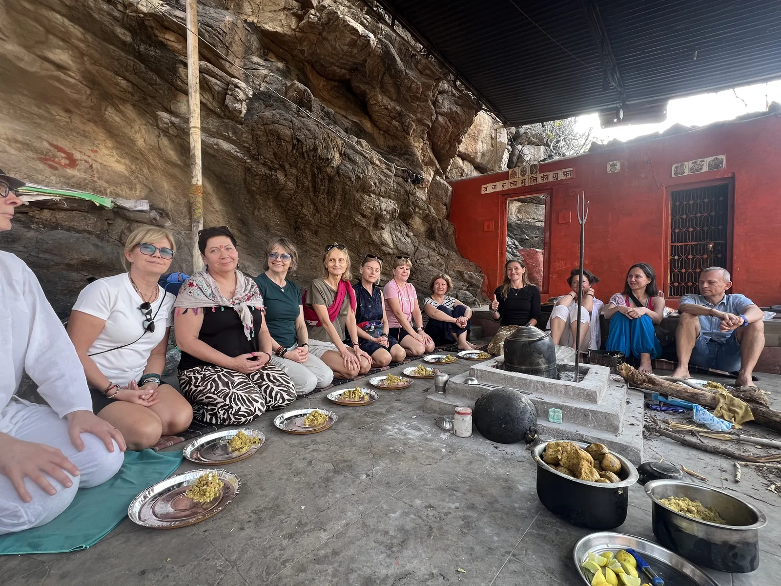 Visitors share food in the setting of Augustya Muni Cave