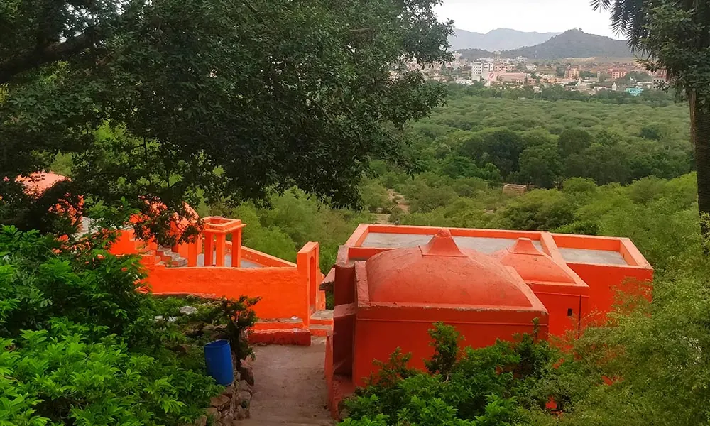 A small temple and green hillside in rural Pushkar